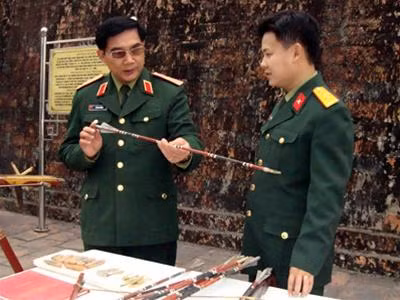 Thiếu tướng Lê Mã Lương và Thượng úy Phạm Vũ Sơn kiểm tra mũi tên trước khi bắn thử nghiệm.