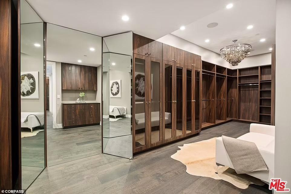 Biệt thự của cặp đôi người mẫu dĩ nhiên không thể thiếu phòng quần áo rộng rãi, với rất nhiều ngăn tủ gỗ, thậm chí đặt cả ghế sô pha trong trường hợp băn khoăn không biết chọn gì để mặc.