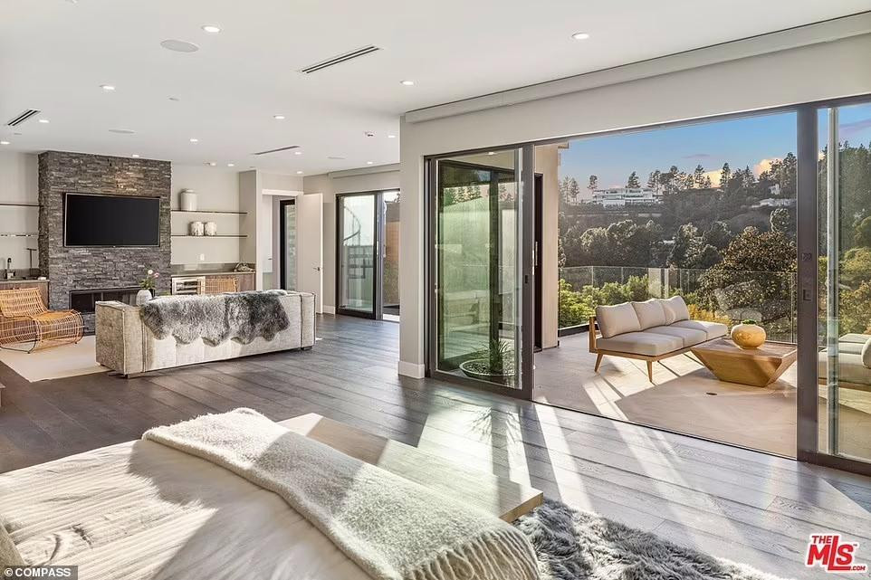 Phòng ngủ chính vốn rất rộng, càng thêm rộng hơn khi nối liền với ban công nhờ thiết kế cửa sổ kính lớn. Bài trí giống như phòng hạng sang của khách sạn 5 sao, có đủ từ giường đôi, ghế sô pha để xem TV, lò sưởi, bàn ghế ở ban công để phục vụ ngắm cảnh.