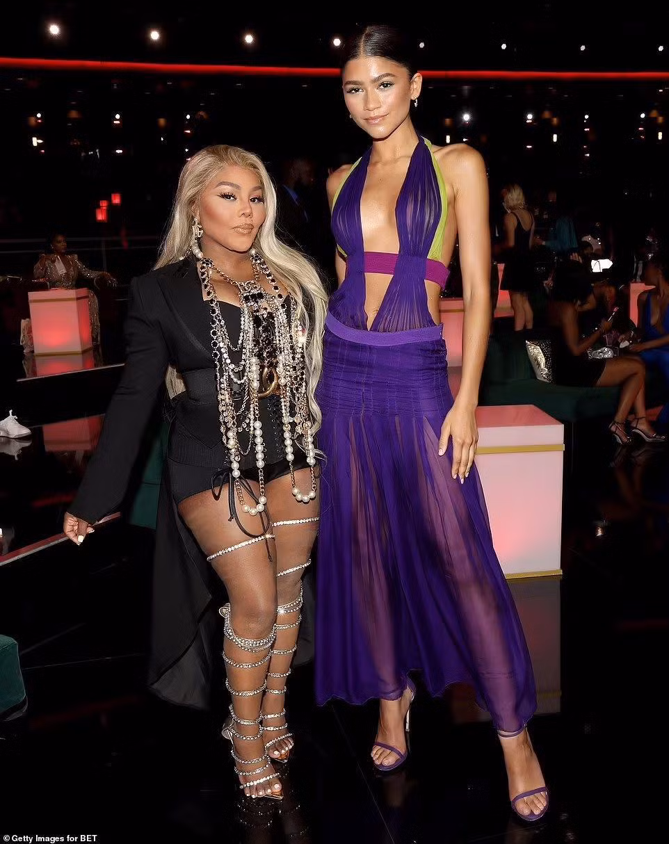 "Bạn gái Người Nhện" Zendaya diện váy tím xuyên thấu còn "thả rông", nhưng không hề phản cảm nhờ thân hình mảnh mai chuẩn siêu mẫu. Đứng cùng người đẹp sinh năm 1996 là rapper Lil 'Kim như mang cả tủ trang sức trên người.