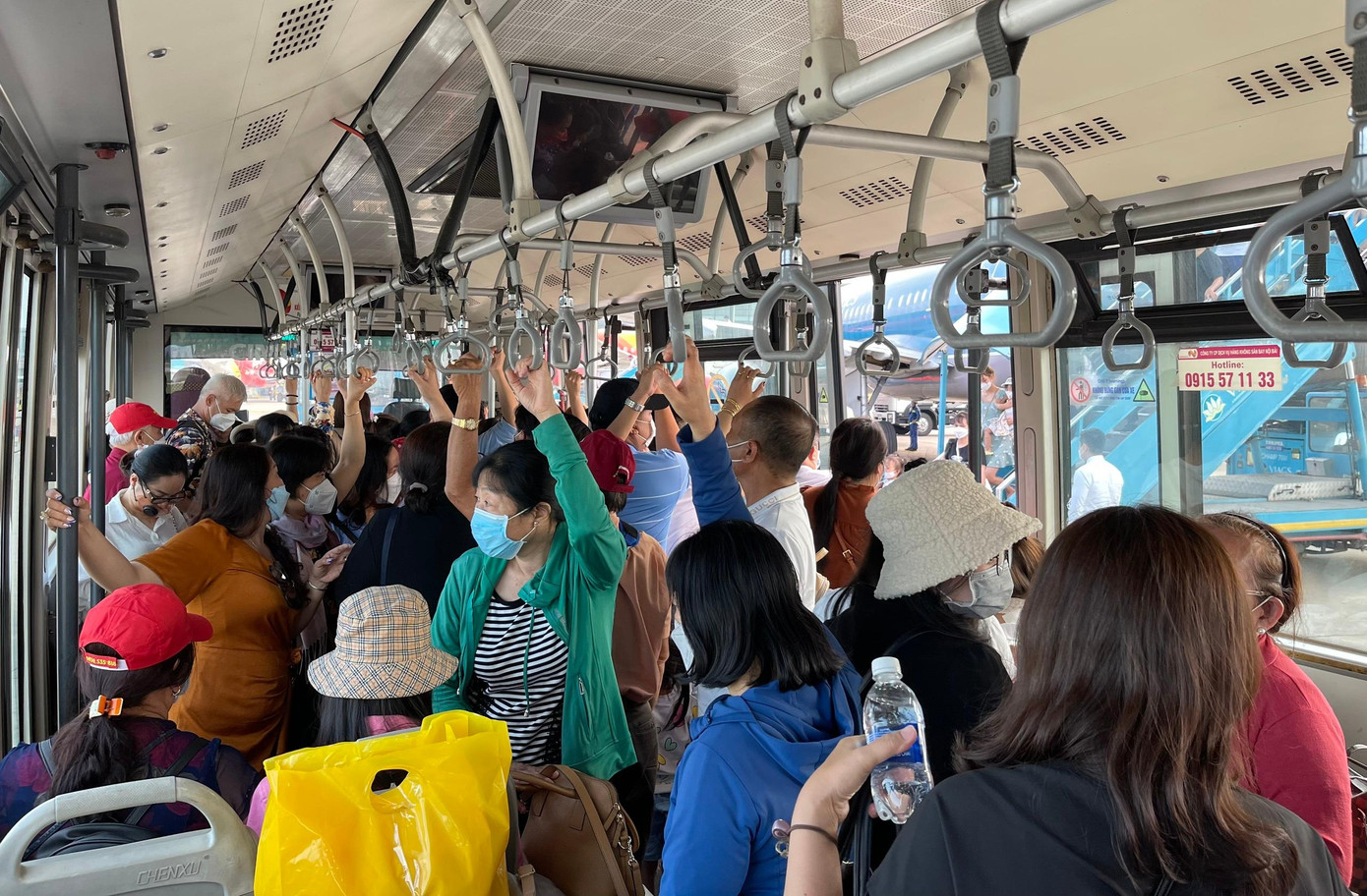 Xe buýt ra máy bay chật kín khách. Ảnh: Như Ý