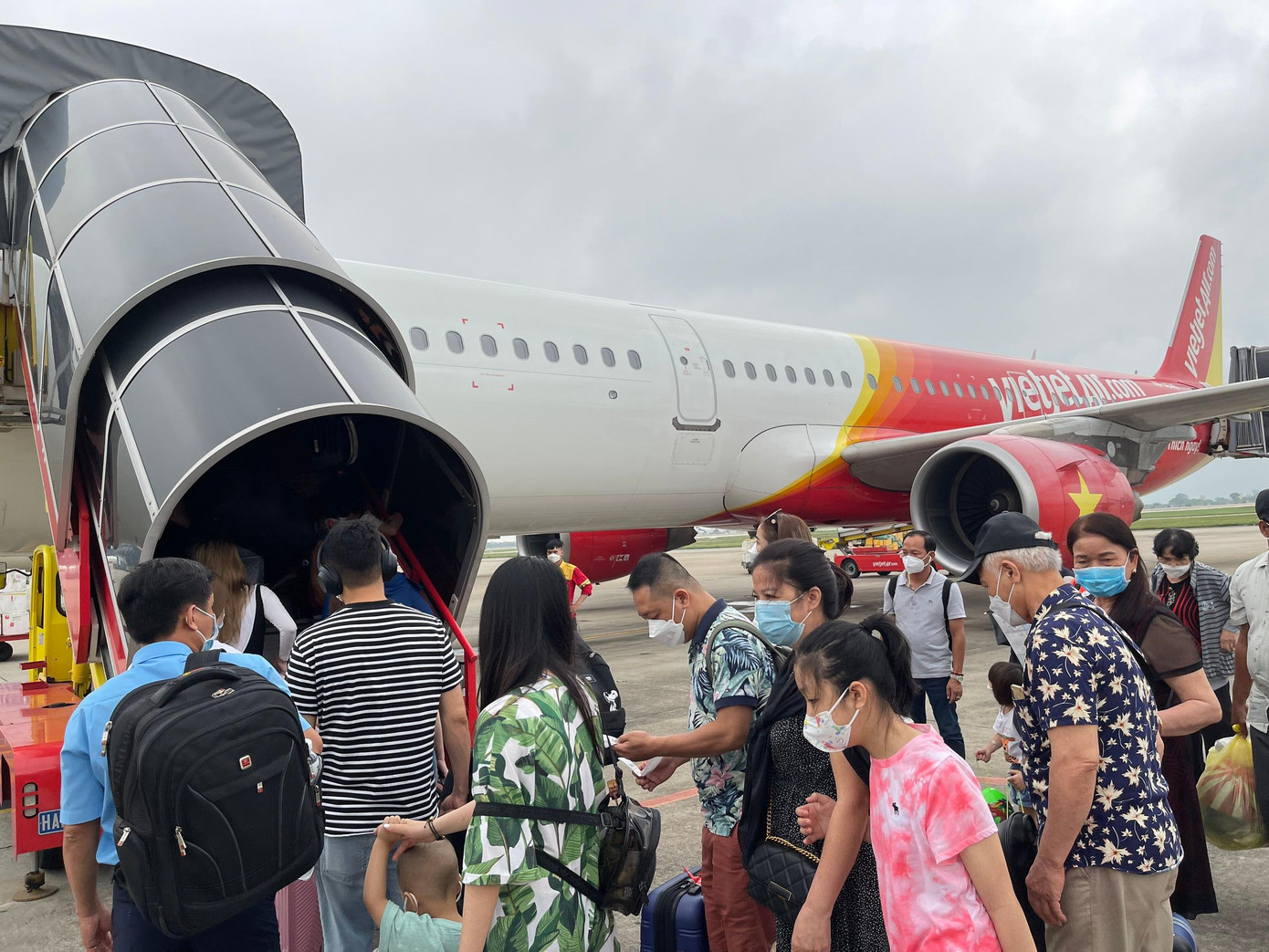 Người dân xếp hàng lên máy bay. Ảnh: Như Ý