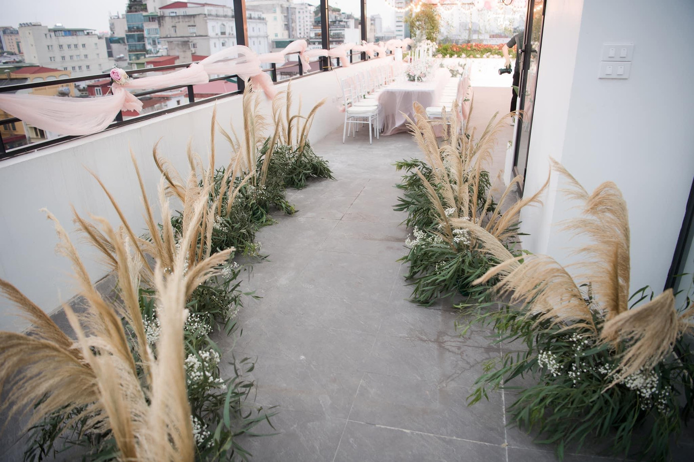 Lối đi vào bữa tiệc được trang trí cầu kỳ với cỏ lau.