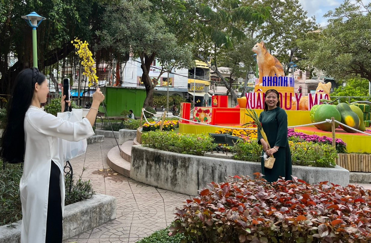 Hai thiếu nữ chụp hình tại linh vật mèo ở Công viên Yến Phi. Ảnh L.H