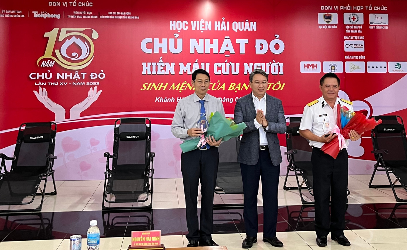 Ông Nguyễn Hải Ninh (giữa) thay mặt Ban tổ chức tặng hoa, biểu trưng cho Ban Chỉ đạo Vận động hiến máu tình nguyện tỉnh Khánh Hòa và Học viện Hải quân. Ảnh C.H