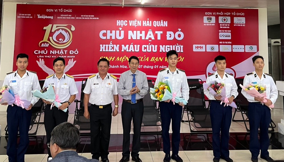 Ông Đinh Văn Thiệu (thứ 4 bên phải) tặng hoa cho các tình nguyện viên có thành tích xuất sắc trong phong trào hiến máu của Học viện Hải quân. Ảnh C.H