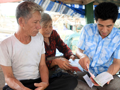 Cán bộ địa phương đang hướng dẫn ông bà Cầm các thủ tục hành chính. Cán bộ địa phương đang hướng dẫn ông bà Cầm các thủ tục hành chính