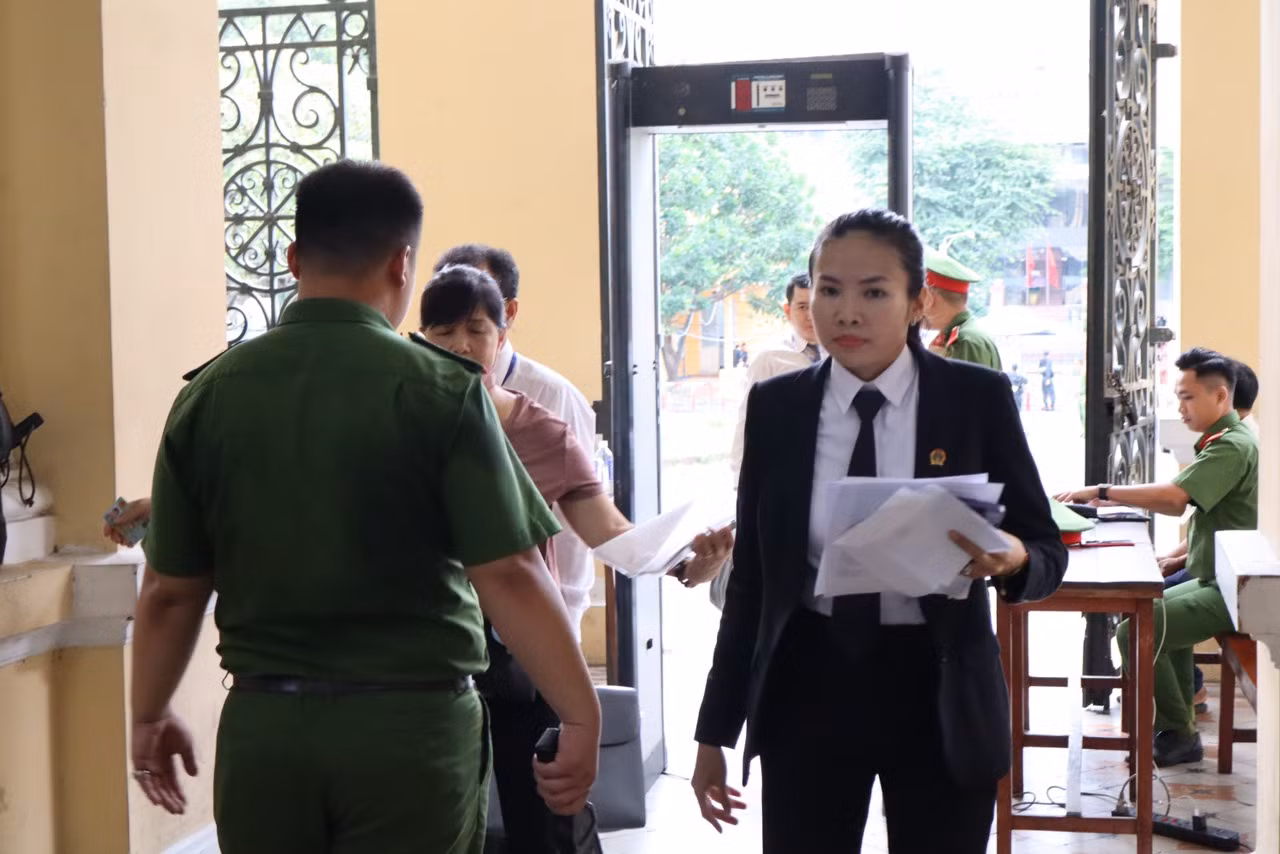Bà Nguyễn Thị Kiều Trang, cán bộ TAND TPHCM hướng dẫn người tham dự phiên tòa sáng nay 6/8. Ảnh: Tân Châu.