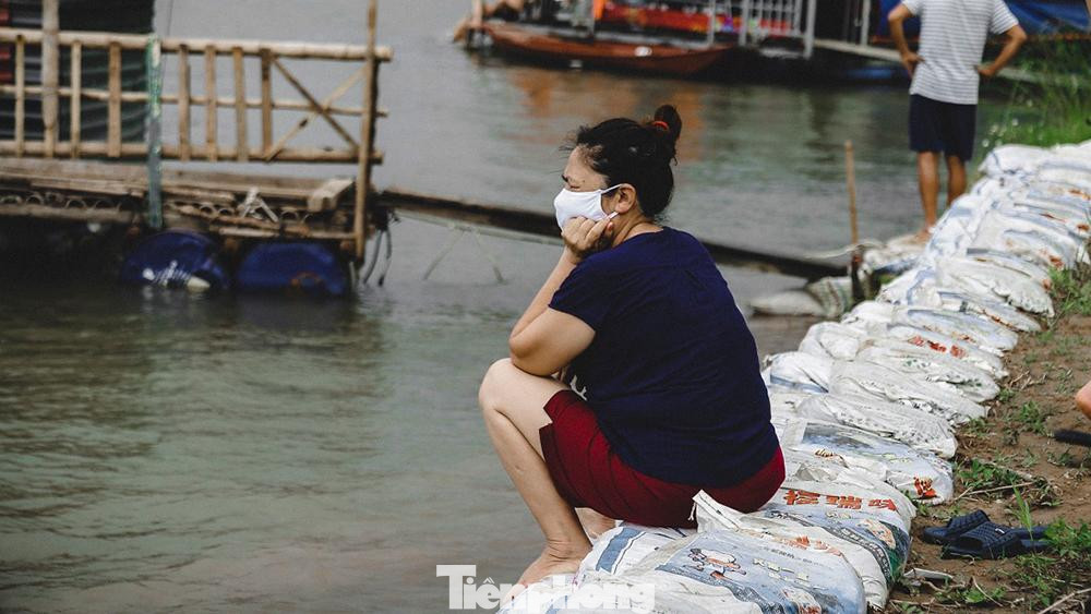 Có người ngồi trên bờ đeo khẩu trang để đợi cháu. Có người ngồi trên bờ đeo khẩu trang để đợi cháu.