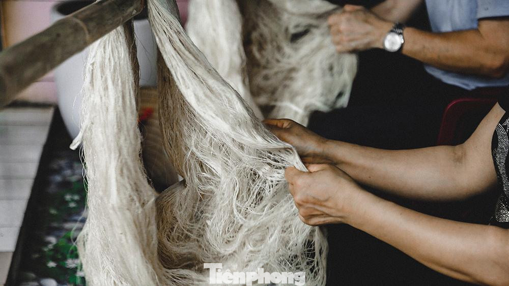 Người thợ vuốt từng sợi kiểm tra lại chất lượng tơ.