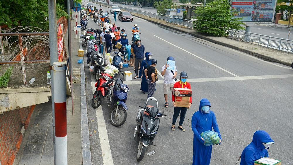 Dù trời nắng, người dân vẫn tập trung đến các chốt kiểm soát khá đông, ai nấy đều khệ nệ bê các thùng nhu yếu phẩm trên tay, chờ đến lượt gửi đồ.