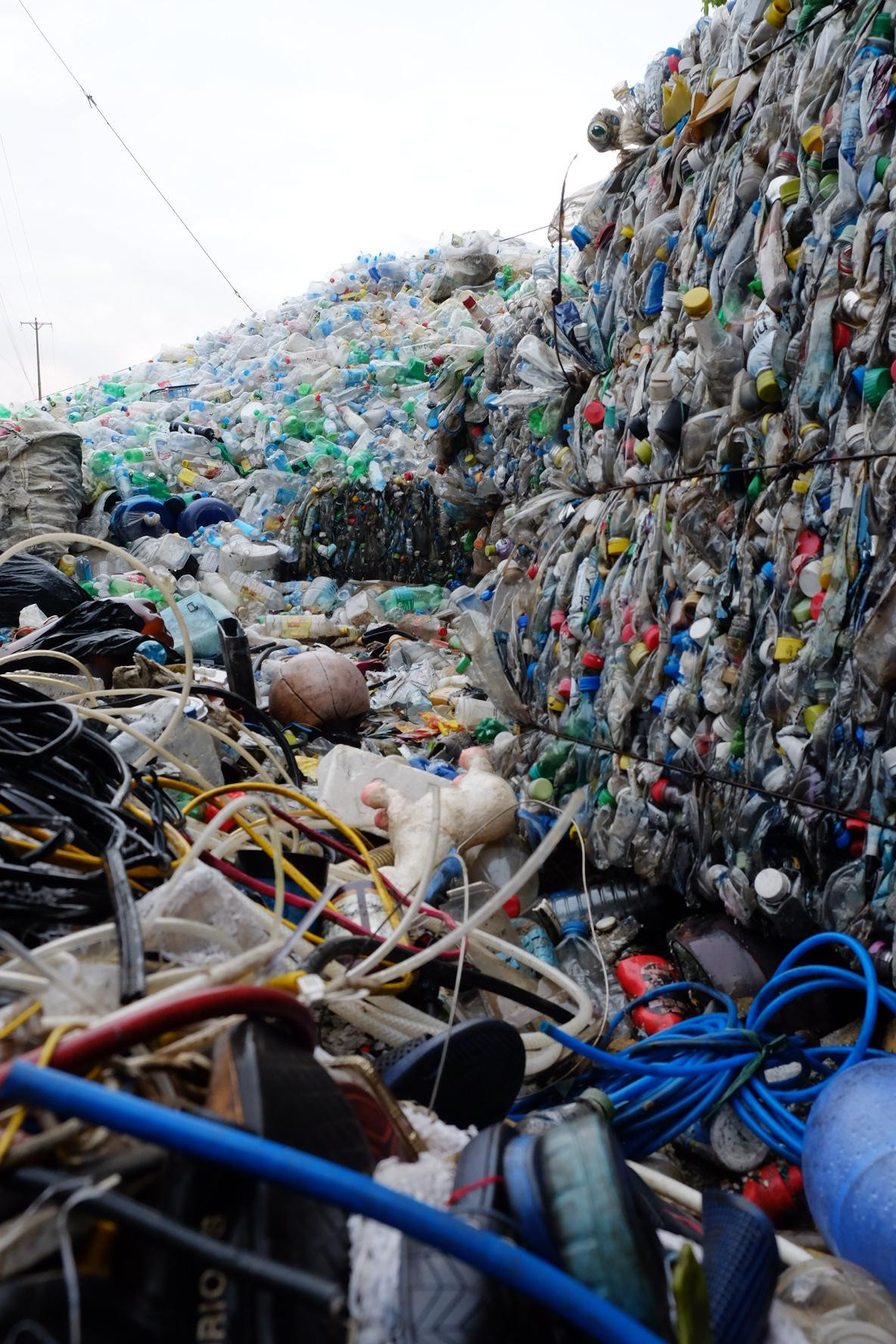 Rác thải nhưa đủ loại từ chai lọ, tivi... đến ống nước được vận chuyển về đây sau đó cho vào máy ép cán vụn. Các xưởng tái chế hoạt động liên tục, cùng với đó là cái núi phế liệu xuất hiện khắp mọi nơi.