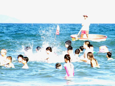 Phơi mình giữa nắng gắt, những nhân viên cứu hộ canh gác cho người tắm biển. Ảnh: Cát Hiền