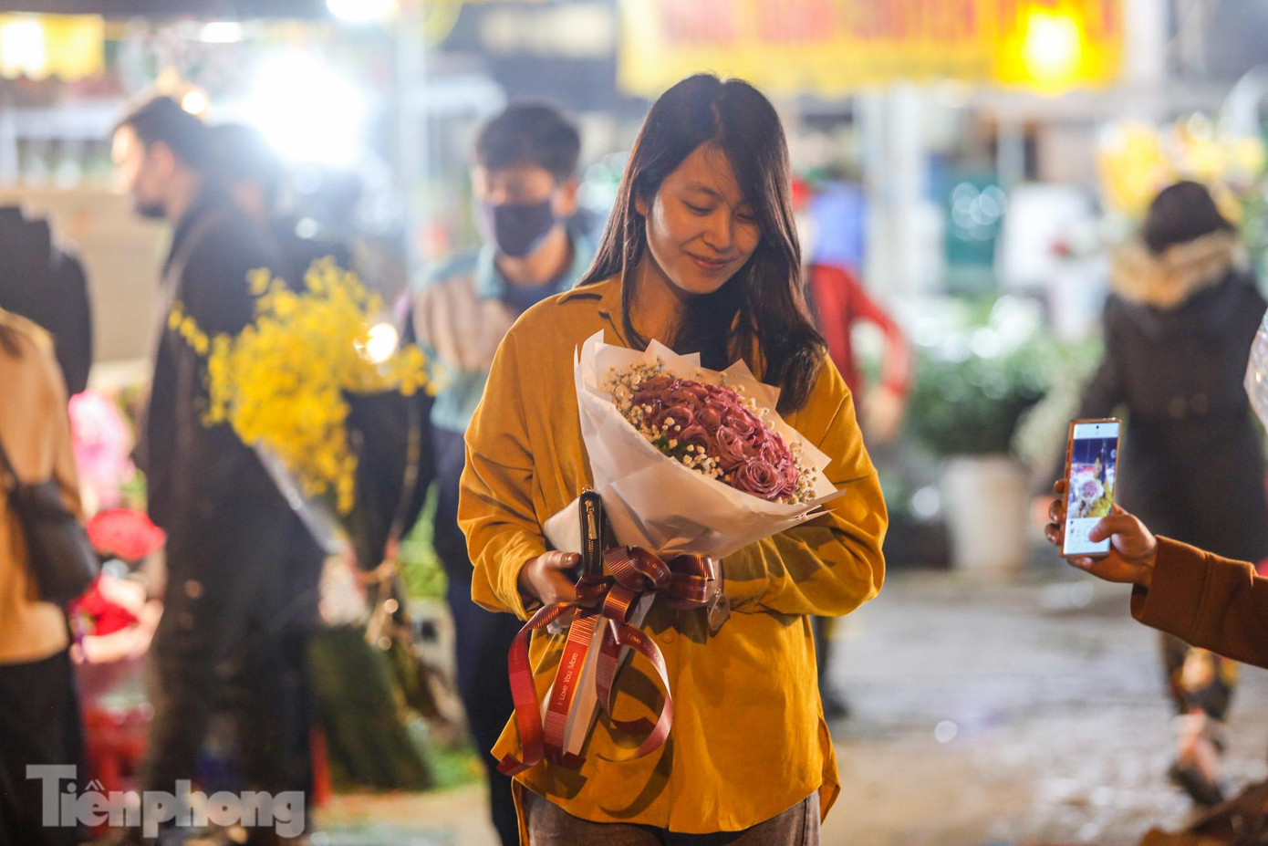 Một bạn nữ được tặng hoa ngay tại chợ Quảng Bá dịp 8/3.