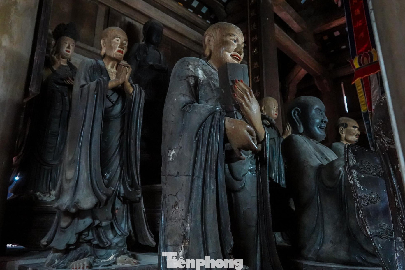 Mối đục loang lổ, thân và mặt tượng bị bong tróc phần sơn.