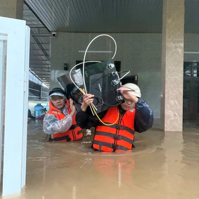 Công an thị trấn Lao Bảo hỗ trợ sơ tán người và tài sản đến nơi an toàn. Ảnh: Anh Trung