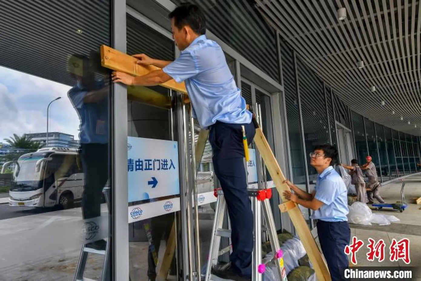 Nhân viên cảng biển lắp đặt thanh gỗ ở các lối ra vào tại cảng Hải Khẩu, Hải Nam.