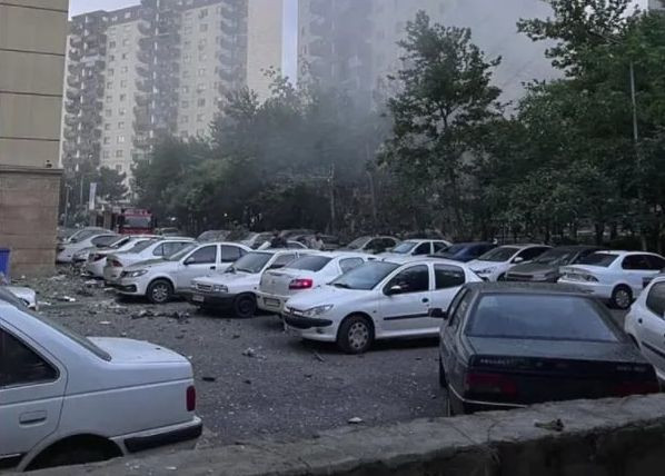 Các mảnh vỡ từ một tòa nhà chung cư rơi xuống các bãi đỗ xe. Ảnh: AP