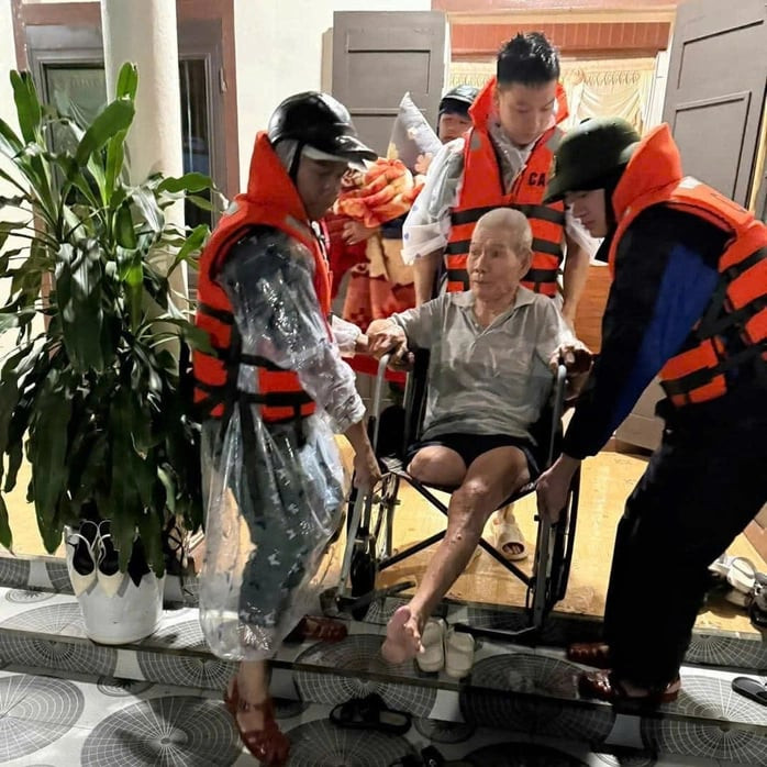 Công an thị trấn Lao Bảo hỗ trợ sơ tán người và tài sản đến nơi an toàn. Ảnh: Anh Trung