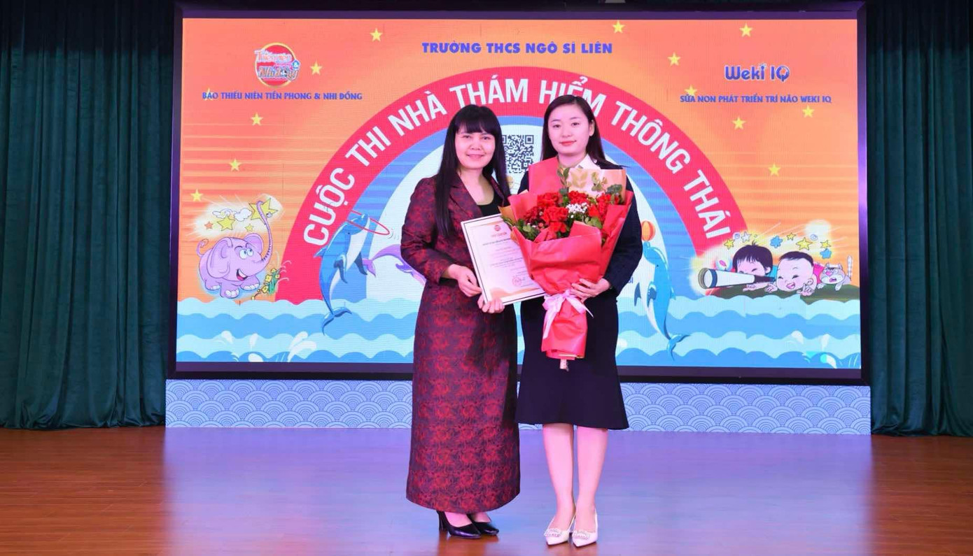 Nhà báo Trần Lan Phương (bìa trái) - Phó Tổng Biên tập báo Thiếu niên Tiền phong và Nhi đồng tặng hoa cảm ơn nhà giáo Phạm Thu Hà - Bí thư Chi bộ, Hiệu trưởng nhà trường và bà Bùi Thị Phượng - Đại diện nhãn hàng sữa non Weki IQ. Ảnh: Trường Phạm