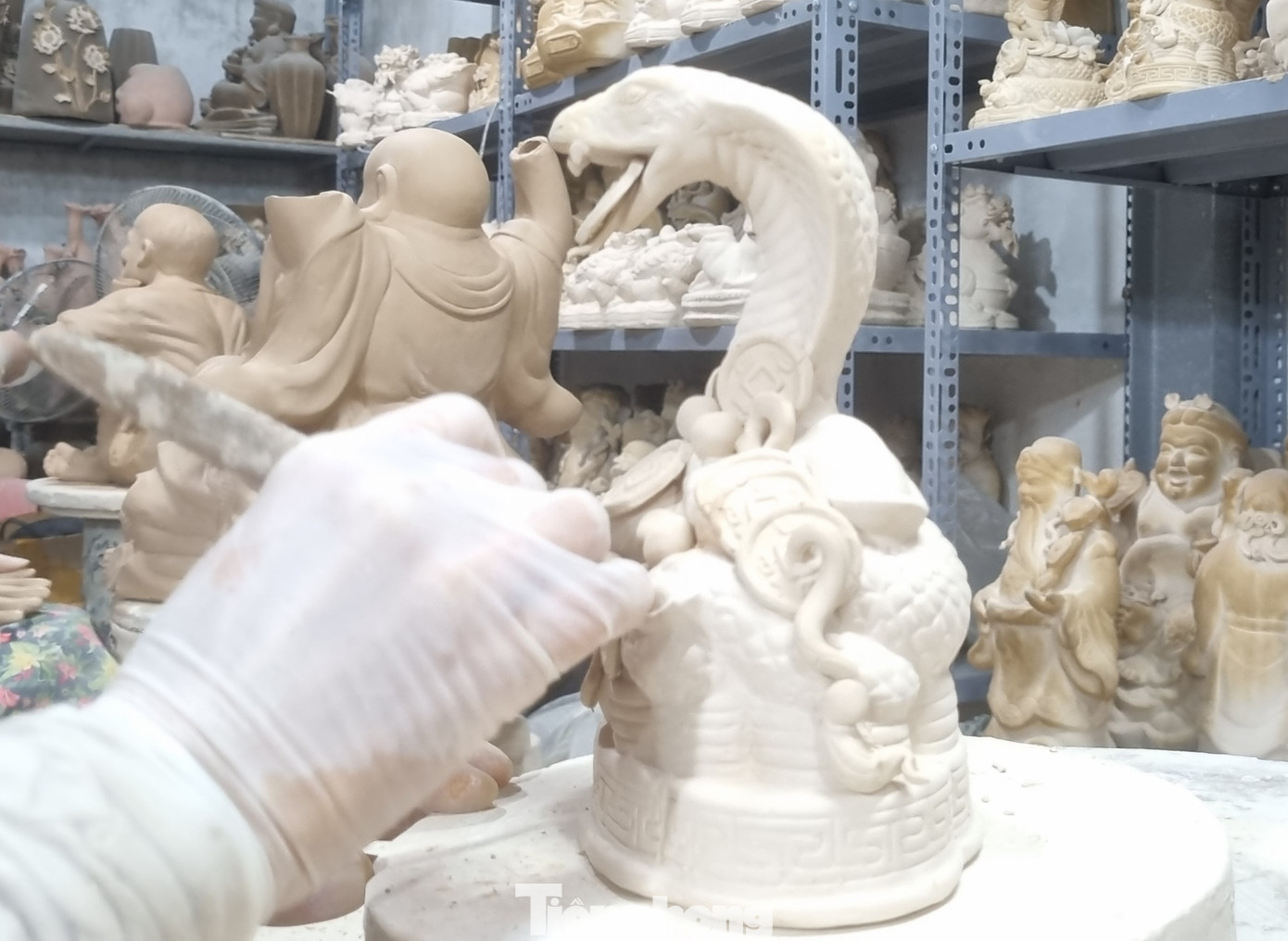 Người thợ gốm tỉ mỉ vẽ từng họa tiết tinh xảo lên linh vật rắn.