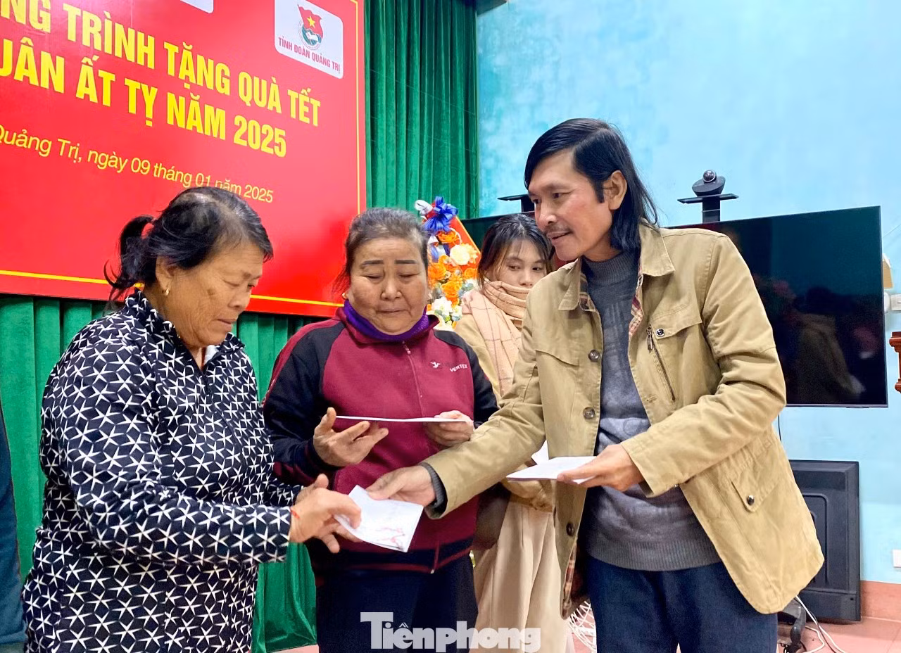 Nhà báo Hữu Thành, phóng viên báo Tiền Phong thường trú tại tỉnh Quảng Trị trao quà Tết cho bà con nghèo.