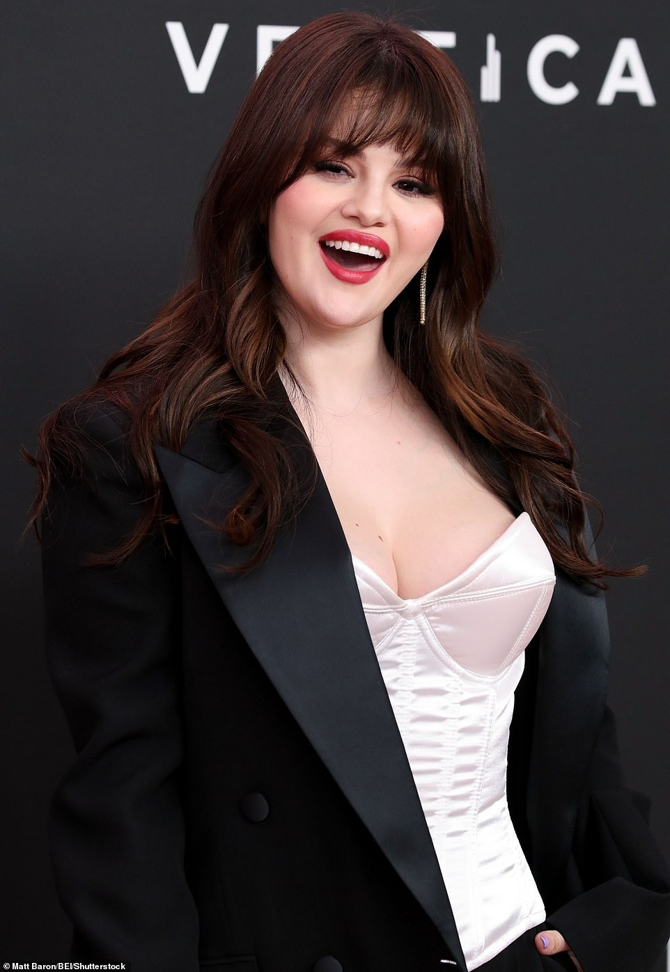 Vóc dáng của Selena có thể không mảnh mai bằng Nicola và Victoria nhưng sự gợi cảm chắc chắn lấn át. Chiếc áo trắng dáng corset giúp nữ ca sĩ sinh năm 1992 khoe vòng một. Áo vest phom rộng, cùng quần baggy không chỉ che được khuyết điểm hình thể, còn làm tăng sự thanh lịch. Trang điểm mắt khói kết hợp màu son môi đỏ thực sự nâng tầm nhan sắc cho Selena. Ảnh: Shutterstock.