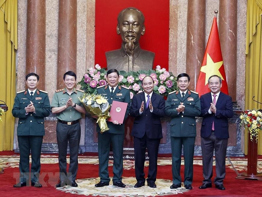 Chủ tịch nước Nguyễn Xuân Phúc, Thống lĩnh các lực lượng vũ trang nhân dân, Chủ tịch Hội đồng Quốc phòng và An ninh, trao Quyết định thăng quân hàm từ Trung tướng lên Thượng tướng đối với đồng chí Huỳnh Chiến Thắng, Uỷ viên Trung ương Đảng, Phó Tổng Tham mưu trưởng Quân đội nhân dân Việt Nam. (Ảnh: Thống Nhất/TTXVN)