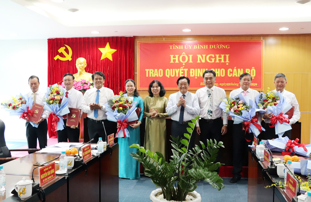 Lãnh đạo tỉnh Bình Dương trao quyết định và tặng hoa chúc mừng các cán bộ Ảnh: Phương Chi