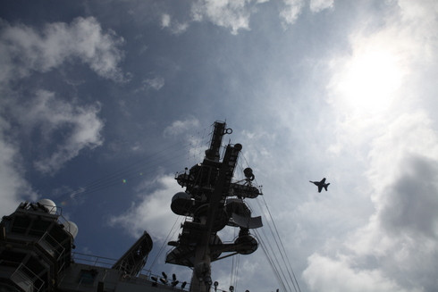 Một chiếc máy bay đang bay ngang qua tháp điều khiển trên tàu