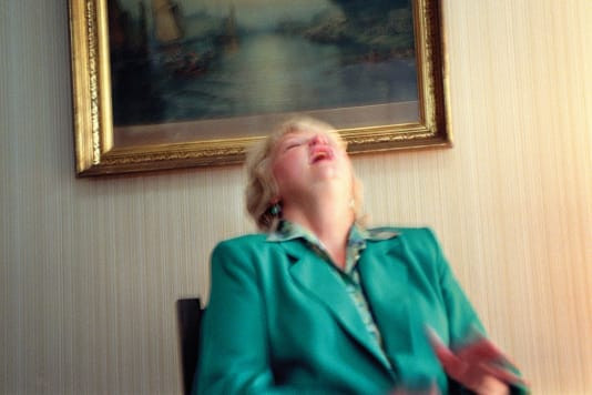 Gretchen Clark, một bà đồng thế hệ thứ năm trong Lily Dale, cười trước một truyện cười mà cô ấy nói rằng anh trai đã khuất của cô ấy vừa kể cho nghe. Một lúc sau, Clark nói với Taggart rằng cô ấy có một tin nhắn từ người dì quá cố của nhiếp ảnh gia. Ảnh: Shannon Taggart.