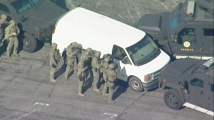 Cảnh sát tiếp cận xe tải trắng mà sau đó họ phát hiện thi thể tay súng Huu Can Tran đã sát hại 10 người, làm bị thương 10 người khác. Ảnh: ABC News.