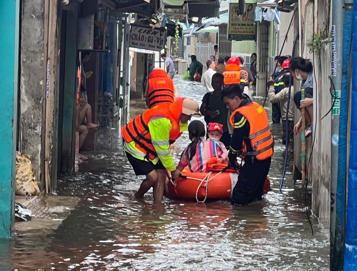 Cán bộ chiến sĩ hỗ trợ người dân sống tại khu vực nước ngập sâu.