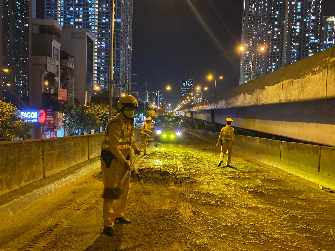 Lực lượng CSGT lấp cát lên lớp dầu. Lực lượng CSGT lấp cát lên lớp dầu.