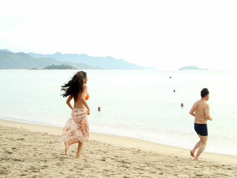 Hai người hào hứng chạy ra để đùa giỡn với sóng biển