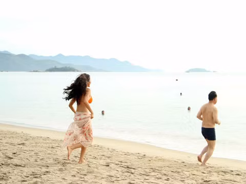 Hai người hào hứng chạy ra để đùa giỡn với sóng biển