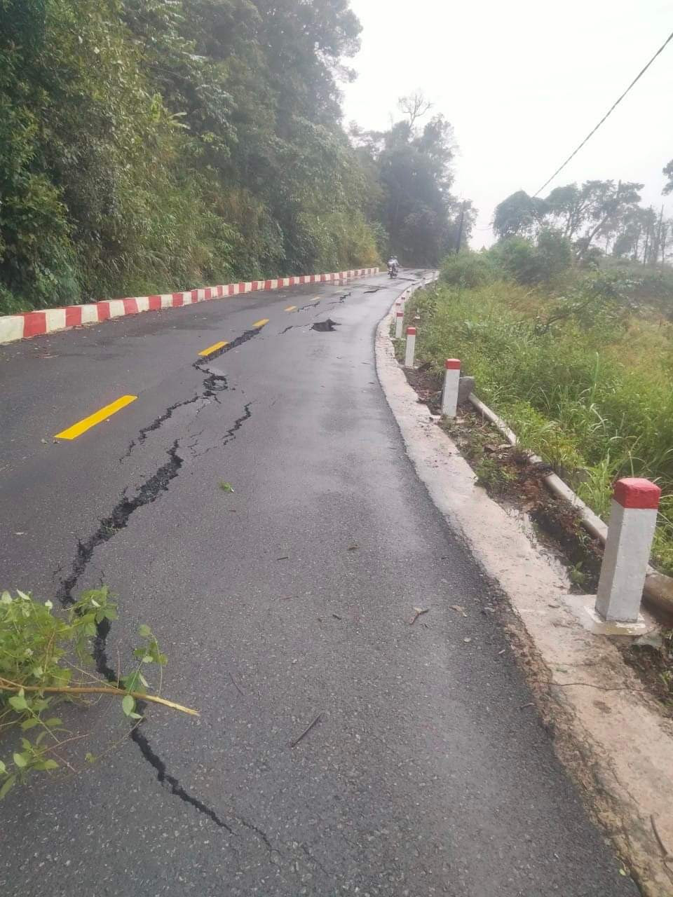 Mặt đường Quốc lộ 24 đoạn qua đèo Vi Ô Lắc xuất hiện nhiều vết nứt lớn.