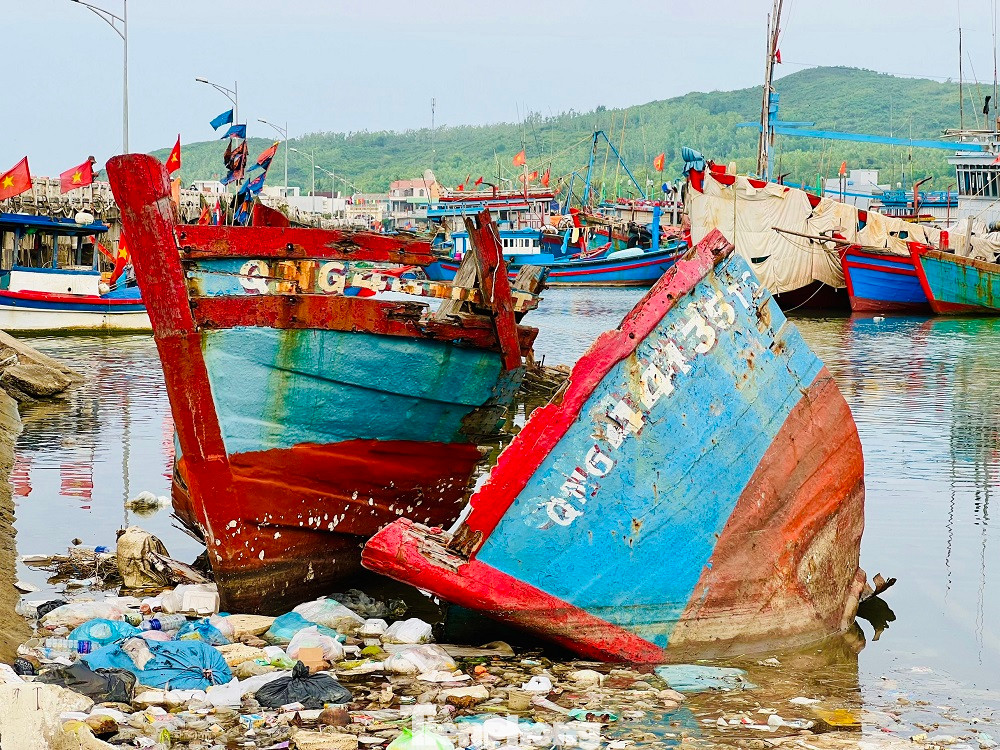 Chị Đoàn Thị Chung (trú phường Phổ Thạnh, thị xã Đức Phổ) cho hay, ngoài xác tàu và rác thải, quanh khu vực cảng cá Sa Huỳnh còn bị ô nhiễm bởi một số cơ sở thu mua và chế biến hải sản xả nước thải trực tiếp chưa qua xử lý. Những hôm trời nắng, nước ở khu vực này đen ngòm. Nhiều ngư dân bị nổi ngứa sau khi lặn xuống nước để kiểm tra thân tàu hoặc kéo tàu lên bờ để sửa. (Ảnh: Nguyễn Ngọc)