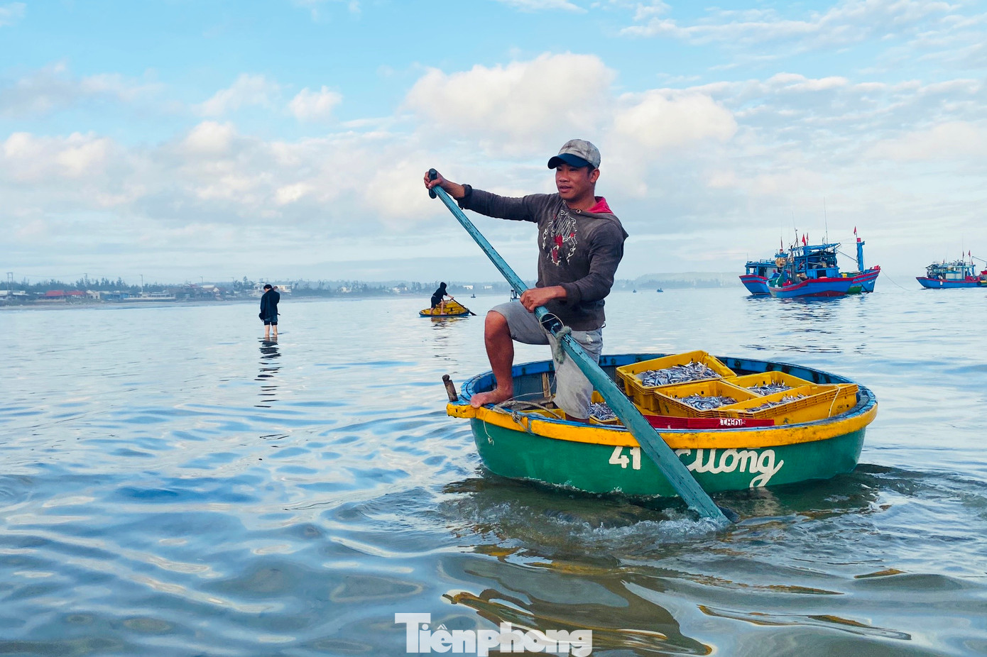 Để đưa hải sản vào bờ, ngư dân sẽ chuyển hải sản từ tàu lớn sang thuyền thúng nhỏ, còn tiểu thương chờ đợi sẵn trên bờ biển để thu mua. Việc thu mua cá diễn ra ngay bên mép sóng. (Ảnh: Nguyễn Ngọc)