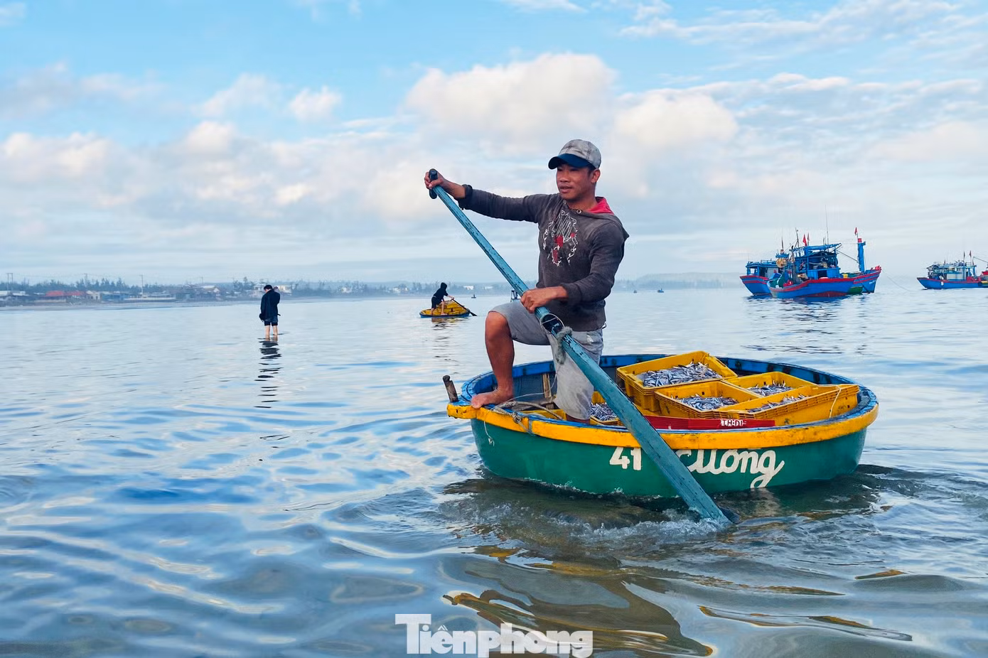 Để đưa hải sản vào bờ, ngư dân sẽ chuyển hải sản từ tàu lớn sang thuyền thúng nhỏ, còn tiểu thương chờ đợi sẵn trên bờ biển để thu mua. Việc thu mua cá diễn ra ngay bên mép sóng. (Ảnh: Nguyễn Ngọc)