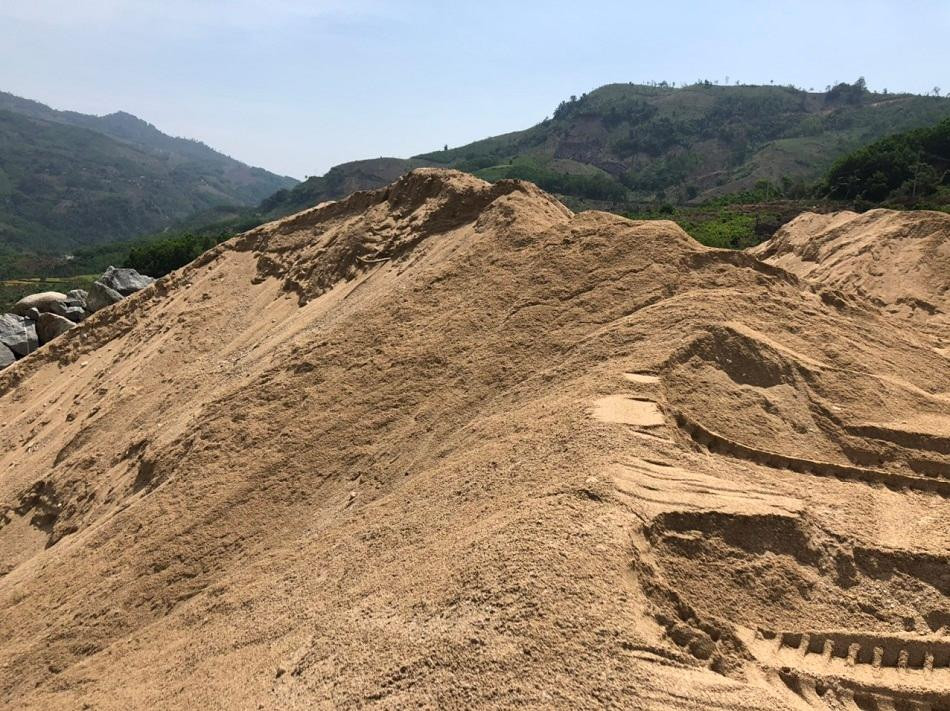 Một bãi cát thu hồi từ việc nạo vét lòng hồ thủy điện Sơn Tây tập kết tại nhiều điểm dọc tuyến đường vào lòng hồ.