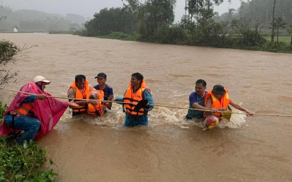 Lực lượng quân đội, công an huyện Ba Tơ (tỉnh Quảng Ngãi) vượt dòng nước lũ chảy xiết để đưa hàng chục người dân ở chỗ có nguy cơ sạt lở cao đến nơi an toàn.