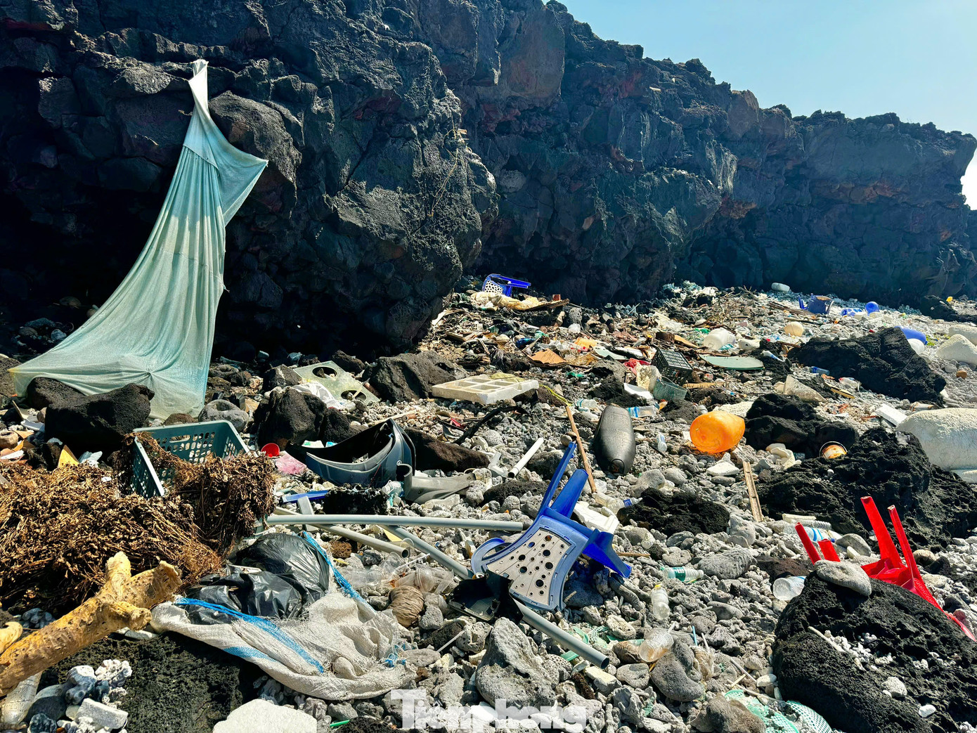 Lẩn khuất trong những vách đá nham thạch, lùm cây là những hàng trăm chai nhựa, thùng xốp, túi nilon, giày dép… đang ngày ngày bủa vây lấy đảo. Ảnh: Nguyễn Ngọc.