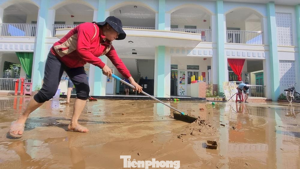 Các giáo viên khẩn trương dọn dẹp bùn đất sau lũ.