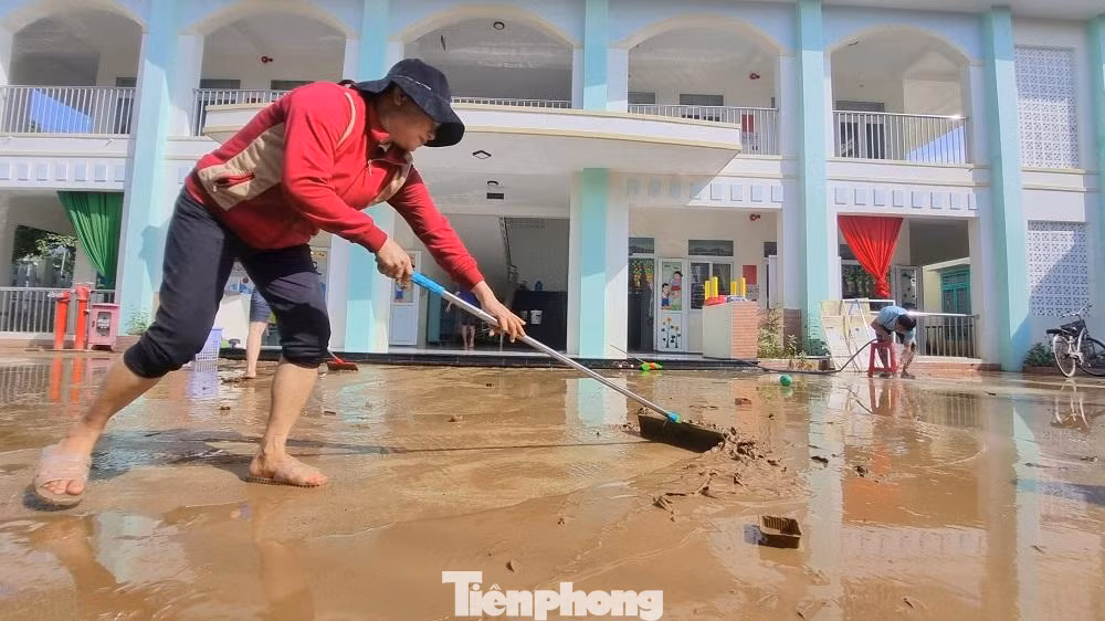 Các giáo viên khẩn trương dọn dẹp bùn đất sau lũ.