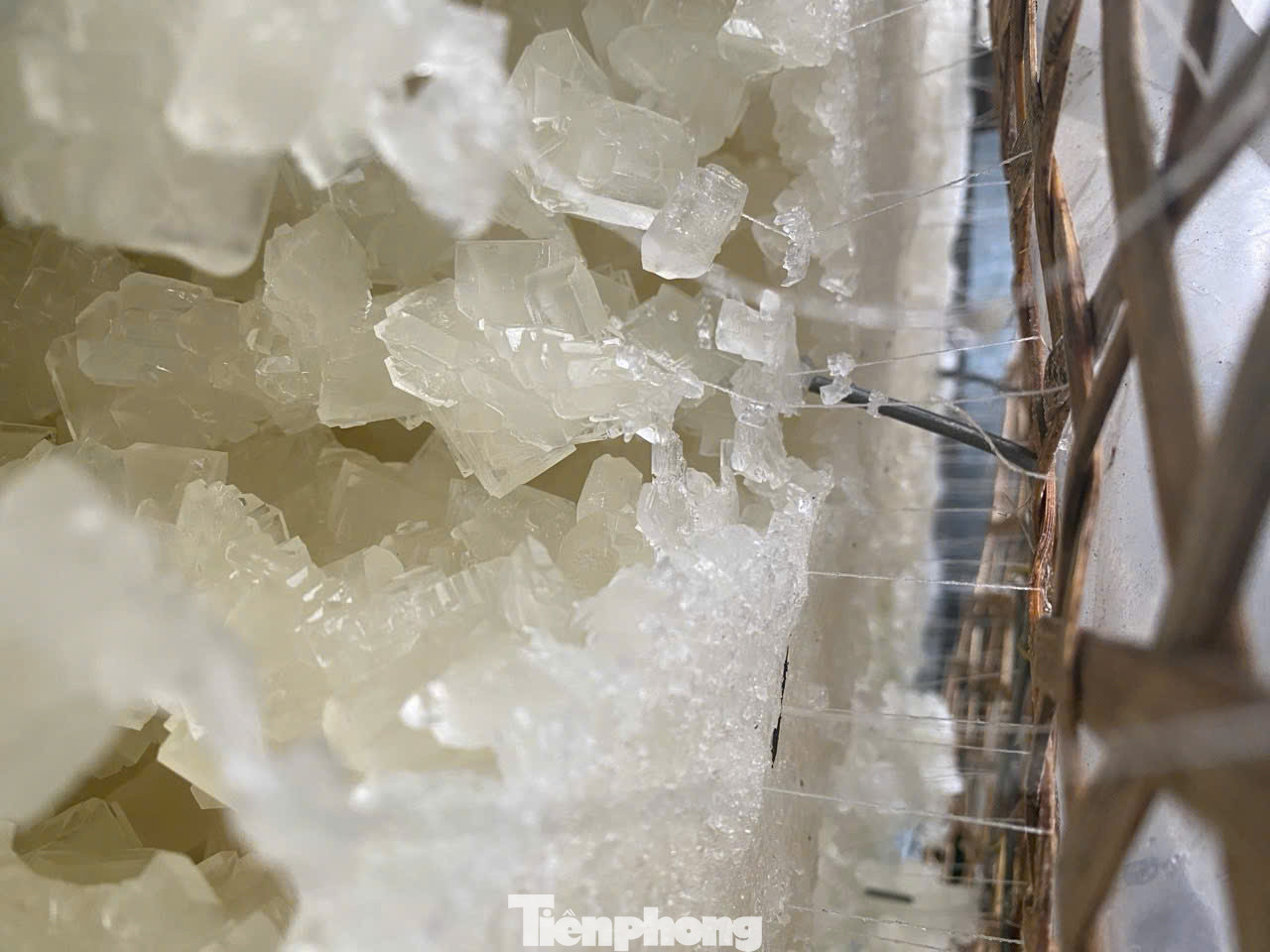 “Để đường kết tinh đều, đẹp cần 2 bí quyết là dùng vỉ chỉ và yếu tố tĩnh. Vỉ chỉ là 2 vỉ tre được cố định bởi khung sắt, chỉ được luồn qua vỉ tre sau đó bỏ vào thùng sắt rồi đổ nước đường vào thùng. Vỉ chỉ sẽ giúp đường phèn kết tinh và bám vào thành từng mảng như đá thạch anh. Bí quyết thứ hai là thùng chứa nước đường phải đặt ở nơi bằng phẳng. Suốt quá trình chờ đường kết tinh không được làm thùng rung động”, bà Lắm nói. Ảnh: Nguyễn Ngọc