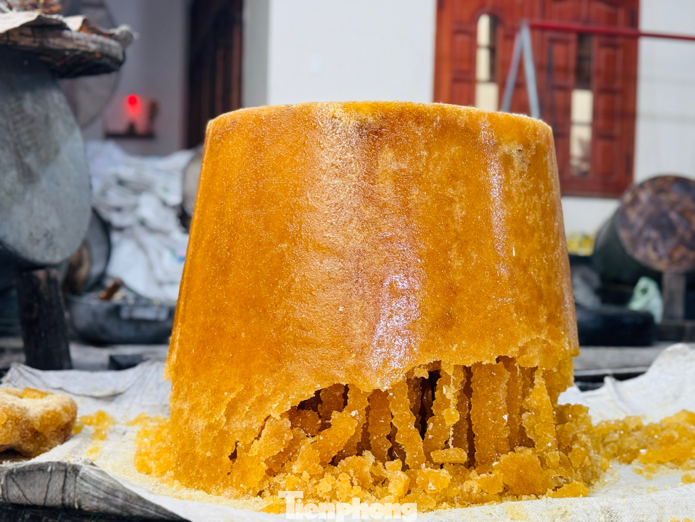 Bà Nguyễn Thị Lắm (70 tuổi, vợ ông Chính) cho hay dùng cách thử đường bằng nước chính xác hơn. Nhỏ nước đường đang sôi vào đĩa nước lạnh nếu các giọt đường kết dính với nhau là đường đã tới, còn giọt đường tan ra là phải nấu thêm. Ảnh: Nguyễn Ngọc