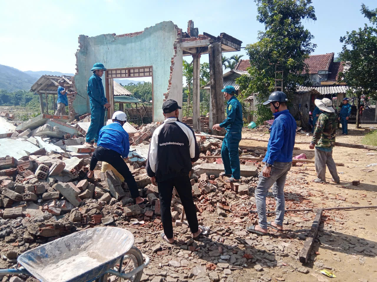 Lực lượng dân quân cùng đoàn viên, thanh niên dọn dẹp nhà giúp bà Đinh Thị Đòa.