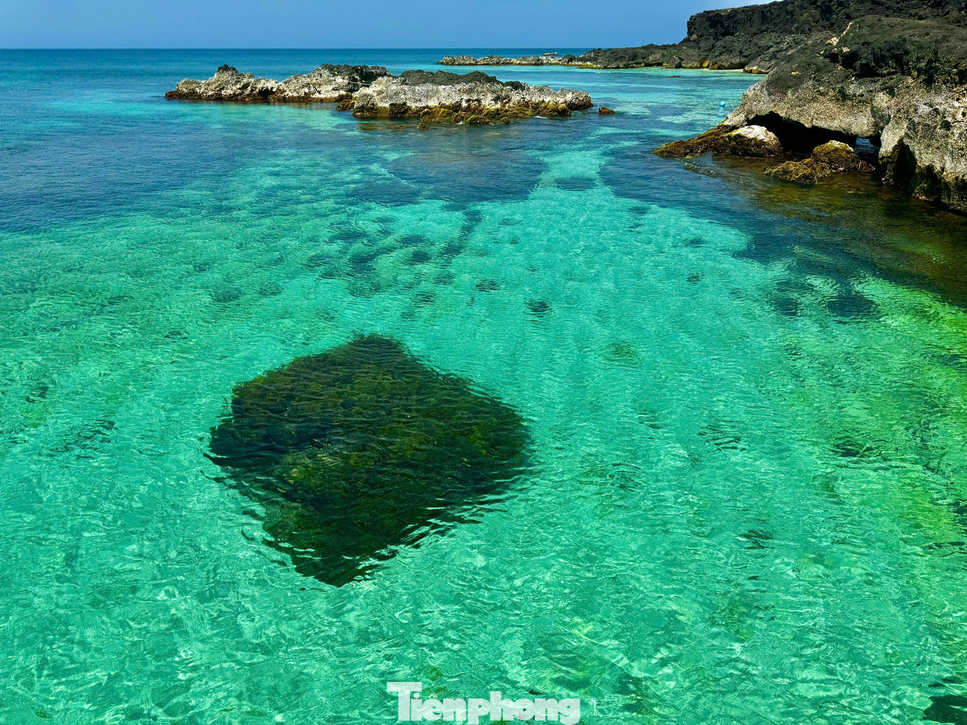 Các vách đá trầm tích núi lửa hàng triệu năm, hòa quyện với màu xanh của nước biển tạo thành một kiệt tác nghệ thuật của thiên nhiên. Ảnh: Nguyễn Ngọc.