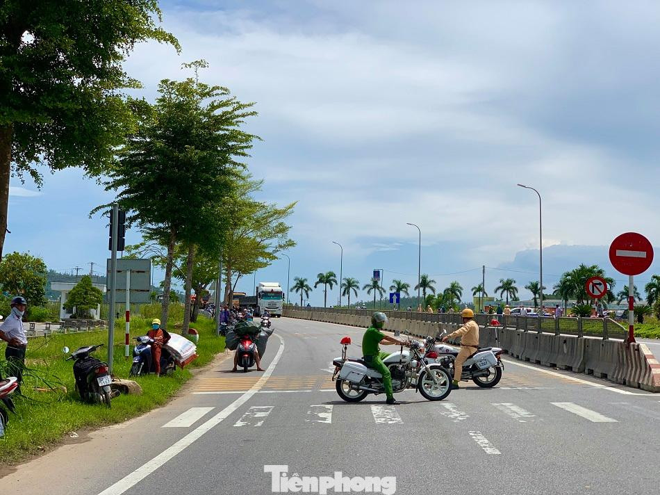 Lực lượng chức năng chặn đường không cho xe lưu thông để di dời cây đa.